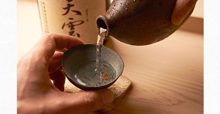 お猪口に日本酒注ぐ